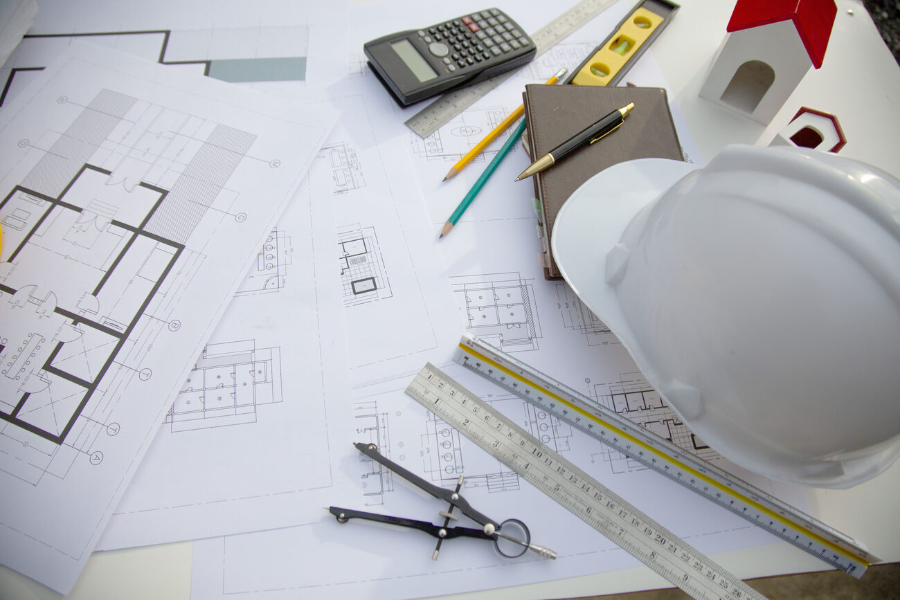 Architectural blueprints, hard hat and precision drafting tools — the engineering discipline behind every ITA PRO build